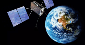 Ein Satellit mit großen Solarmodulen gleitet durch seine Umlaufbahn um die Erde, wobei die blauen Ozeane und braunen Kontinente dieses faszinierenden Standorts teilweise vor der endlosen Schwärze des Weltraums sichtbar sind.
